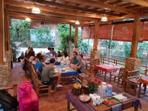 a group of people sitting at tables in a restaurant at Mai Chau Home in Mai Chau