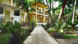 a walkway in front of a building with plants at Mayas Guesthouse in Panglao Island