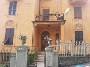 a building with a gate and a porch with potted plants at Casa Brunello in La Spezia