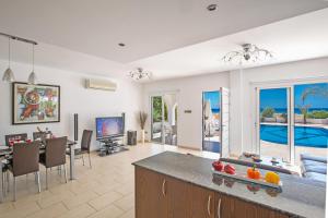 a kitchen and living room with a dining room and a pool at Sunrise Villas in Ayia Napa