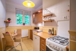 a kitchen with a white stove top oven next to a table at Radunia Canal Apartment in Gdańsk