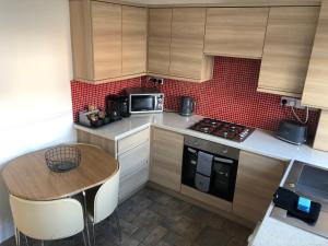 a small kitchen with a table and a microwave at Hilton House in Barnsley