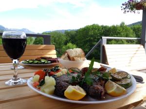 a table with a plate of food and a glass of wine at Camp Sunny Hills in Virpazar