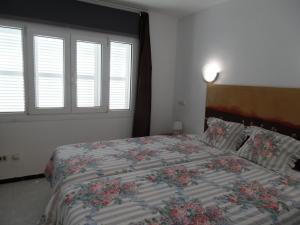 ein Schlafzimmer mit einem großen Bett mit Blumen darauf in der Unterkunft Apartamento Silver Alcudia Blue in Alcúdia