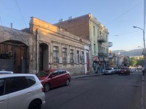 eine Stadtstraße mit auf der Straße geparkt in der Unterkunft Dry Bridge Apartment in Tbilisi City