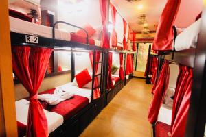 een kamer met 4 stapelbedden en rode gordijnen bij Town Hostel Mumbai - AC Dormitory in Mumbai