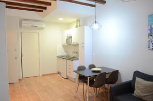 a living room with a table and chairs and a kitchen at Poble Sec Apartments in Barcelona