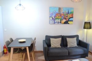 a living room with a blue couch and a table at Poble Sec Apartments in Barcelona