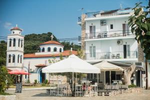 an outdoor cafe with white umbrellas in front of a building at Sea View in Loutraki
