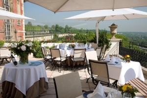 圣日耳曼昂莱Pavillon Henri IV Hotel Restaurant Gastronomique Terrasse的露台上的一组桌椅