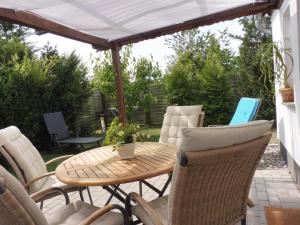 a patio with a table and chairs under a white umbrella at Ferienwohnung Knurrhahn in Ostseebad Karlshagen