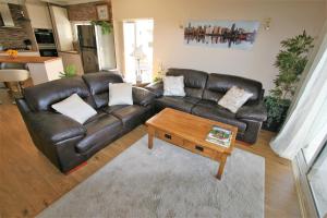 a living room with a leather couch and a coffee table at Alvor Retreat at Vila Marachique in Alvor