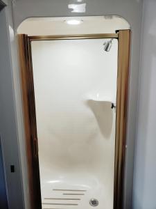 a shower door with a mirror in a bathroom at Hathaway Inn in Panama City