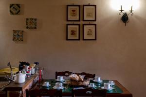 Villa Levante في كاستلبونو: طاولة طعام مع طاولة قماش خضراء وأكواب الشاي