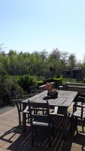 a wooden picnic table with two chairs around it at Hemelse Helderheid in Maasmechelen