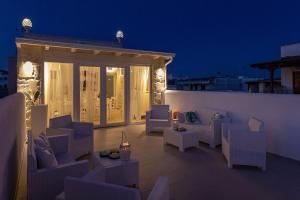 托雷聖喬萬尼的住宿－Petra Bianca，屋顶庭院在晚上配有白色的椅子和桌子