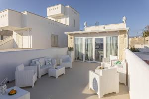 une terrasse avec des chaises et des tables dans l'établissement Petra Bianca, à Torre San Giovanni