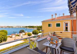 a balcony with chairs and a table with a view of the water at BLUEMARINE in Umag