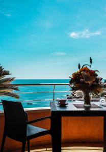 a table with a vase of flowers on a balcony at Taormina Panoramic Hotel in Taormina