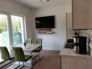 eine Küche mit einem Tisch und einem TV an der Wand in der Unterkunft nagelneue Fewo mit Waldblick 10min zur See Igelring21og in Graal-Müritz