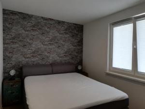 ein Schlafzimmer mit einem Bett und einer Ziegelwand in der Unterkunft nagelneue Fewo mit Waldblick 10min zur See Igelring21og in Graal-Müritz