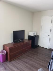 a living room with a flat screen tv on a dresser at Classic Inn and Suites in El Centro