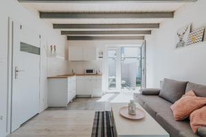 a living room with a couch and a kitchen at Cichy Domek - Podgrzewany Basen, Parking, Aneks Kuchenny in Karwia