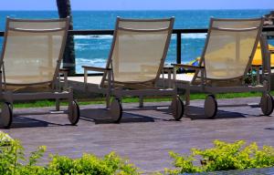 twee schommelstoelen op een terras bij het strand bij Namoa Pousada in Cabo de Santo Agostinho