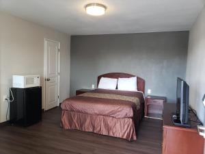 a bedroom with a bed and a tv in it at Classic Inn and Suites in El Centro