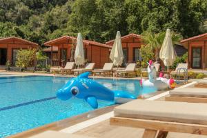 una piscina con un delfín azul en el medio en Dolunay Apart Hotel, en Cıralı