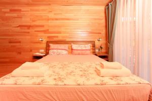 a bedroom with a large bed with wooden walls at Dolunay Apart Hotel in Cıralı