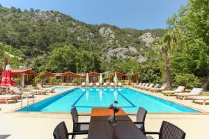 een zwembad in een resort met stoelen en een tafel bij Dolunay Apart Hotel in Cıralı