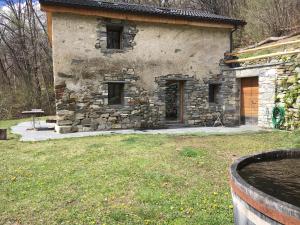 une vieille maison en pierre avec une porte en bois et une cour dans l'établissement Rustico Berlinda, à Bironico 13 autres photos