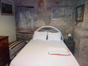 een slaapkamer met een bed in een stenen muur bij Casa de campo in Lovelhe