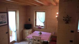 ein Esszimmer mit einem Tisch in einem Holzhaus in der Unterkunft Vista Pelmo in Colle Santa Lucia