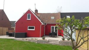 uma casa vermelha com um pátio num quintal em 140m2 Villa in Marstal em Marstal