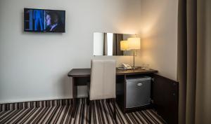 a hotel room with a desk and a mirror at Vilnius City Hotel in Vilnius