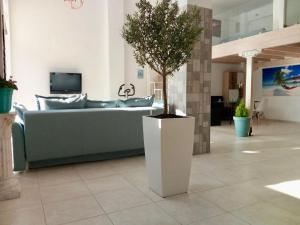 a living room with a couch and a potted tree at Vonitsa Loft Apartment 1 in Vonitsa