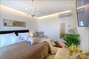 a bedroom with a large bed and a chandelier at Via Porto Rooms in Split