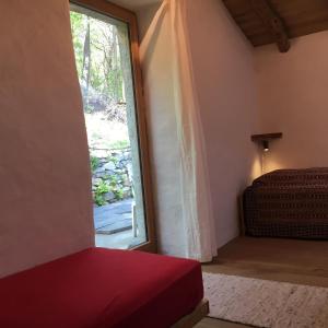 Cette chambre dispose d'une fenêtre, d'un lit et d'une porte. dans l'établissement Rustico Berlinda, à Bironico