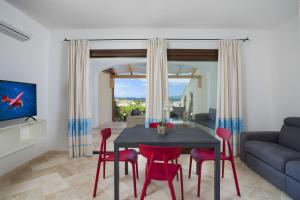 sala de estar con mesa y sillas rojas en Le Maree Apartments en Cannigione