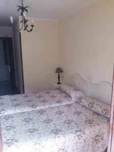 1 dormitorio con 1 cama grande con colcha de flores en Casa Rural La Llosica, en Ribadesella