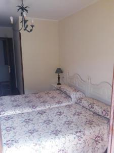 a bedroom with a large bed with a floral bedspread at Casa Rural La Llosica in Ribadesella