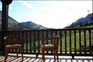2 sillas en un porche con vistas a las montañas en Casa Rural La Llosica, en Ribadesella