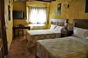 a hotel room with two beds and a television at Mas La Trampa in La Selva del Camp