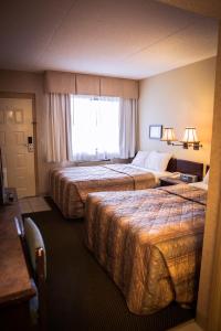 Кровать или кровати в номере Langley Hwy Hotel