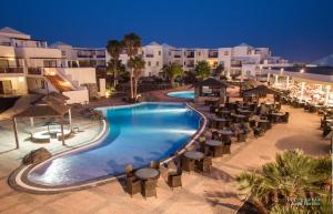 uma vista superior de uma piscina à noite em Vitalclass Lanzarote Resort em Costa Teguise