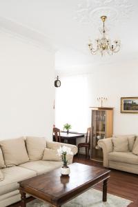 ein Wohnzimmer mit einem Sofa und einem Tisch in der Unterkunft Vintage Style spacious apartment in Klaipėda