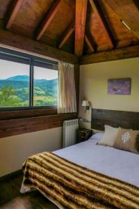 um quarto com uma cama e uma grande janela em La Casona de Abamia em Corao
