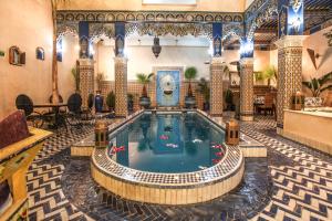 a large swimming pool in a large room at Riad Puchka in Marrakesh
